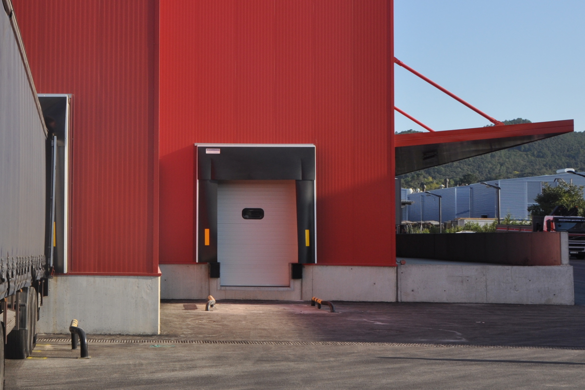 Muelle de carga con rampa retráctil, la puerta seccional cierra por delante de la rampa, proporcionando un alto nivel de estanqueidad.